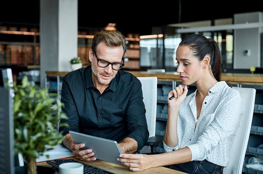 business partners looking at a tablet working together