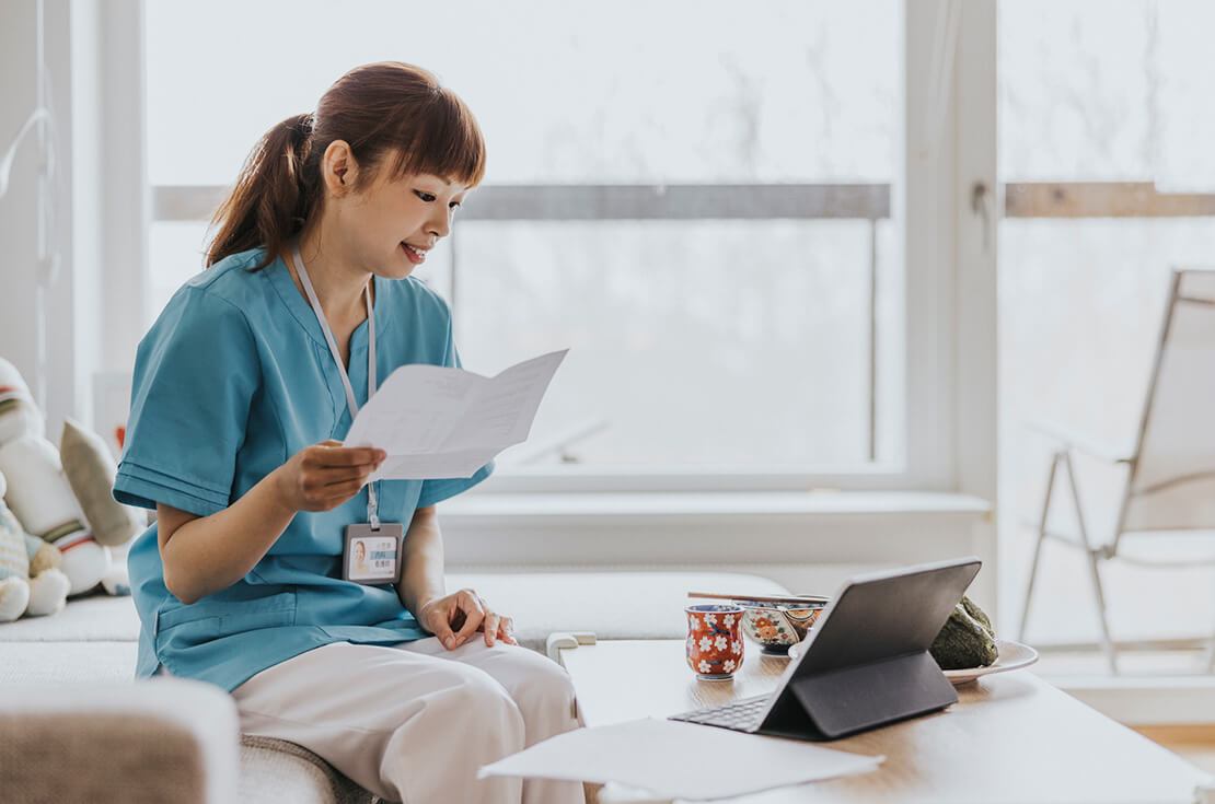 female physician reviewing paperwork and tablet work